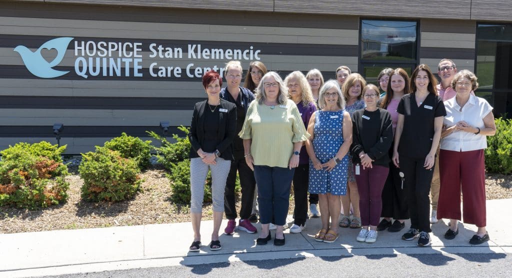 Hospice Quinte staff in front of the Stan Klemencic Care centre on a sunny day