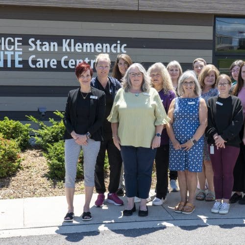 Hospice Quinte staff in front of the Stan Klemencic Care centre on a sunny day