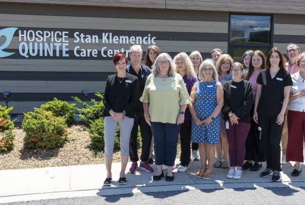 Hospice Quinte staff in front of the Stan Klemencic Care centre on a sunny day